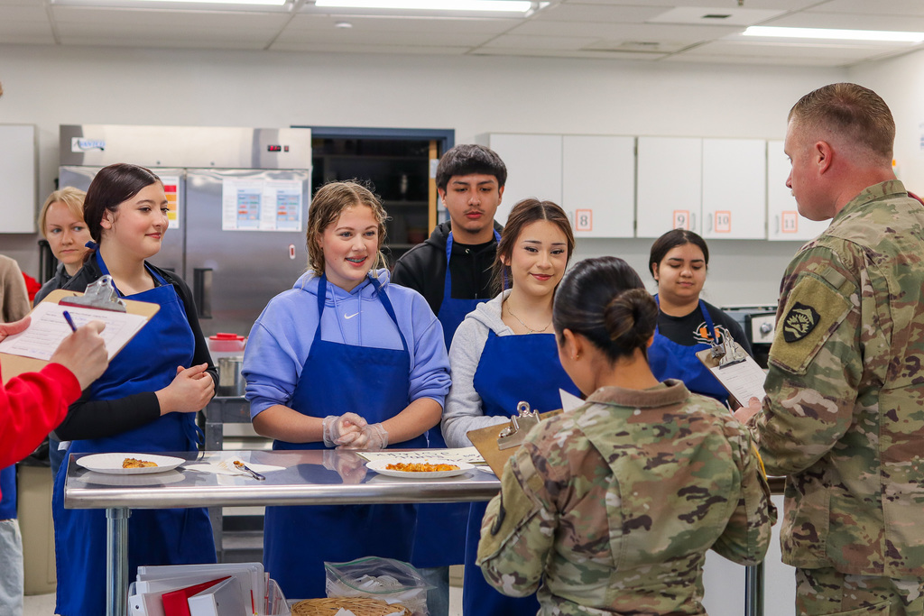students presenting pizza slices to judges 