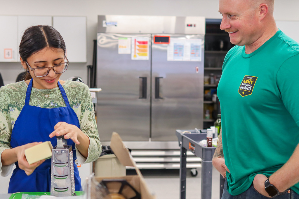 student grating cheese for pizza 