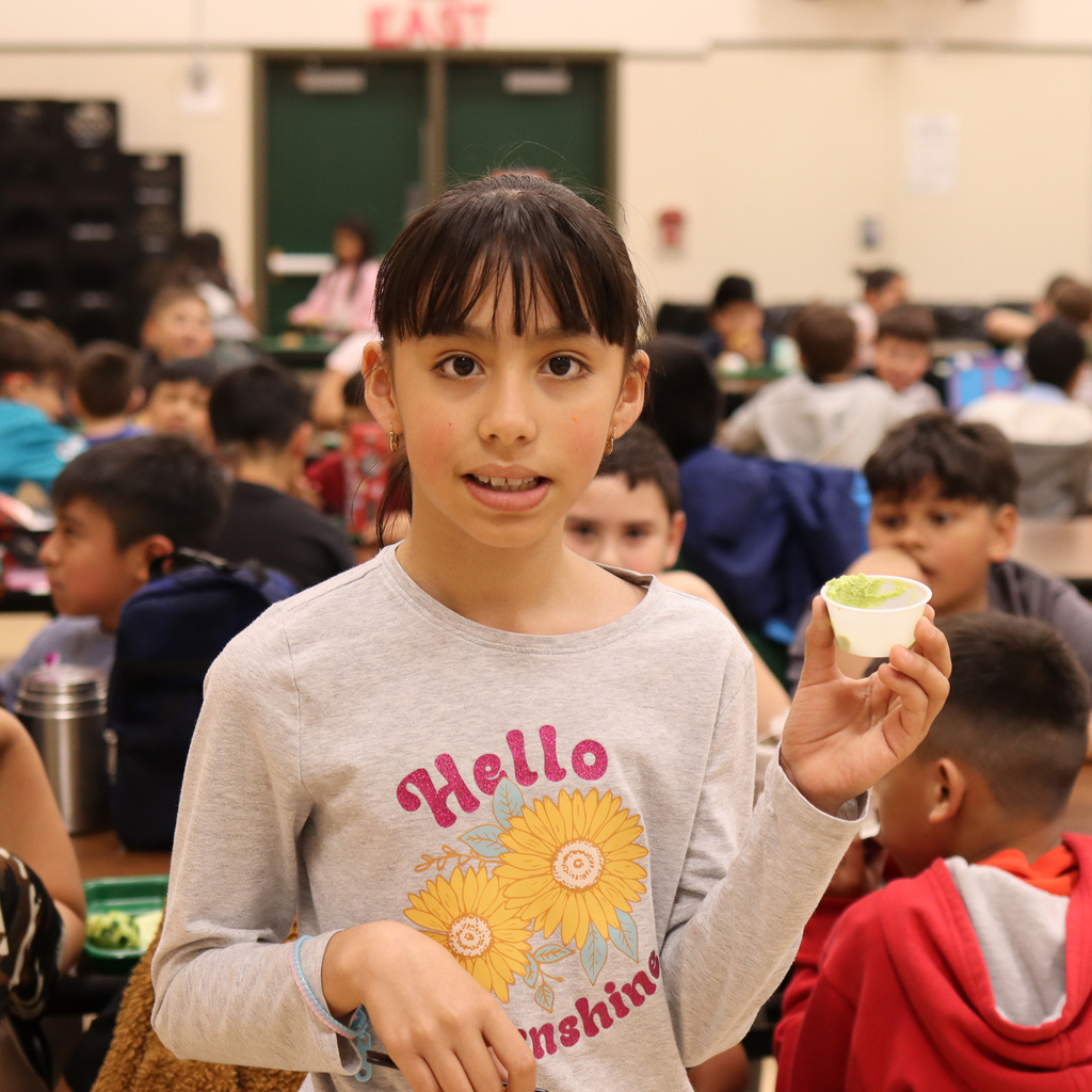 student holding up the green hummus sample 