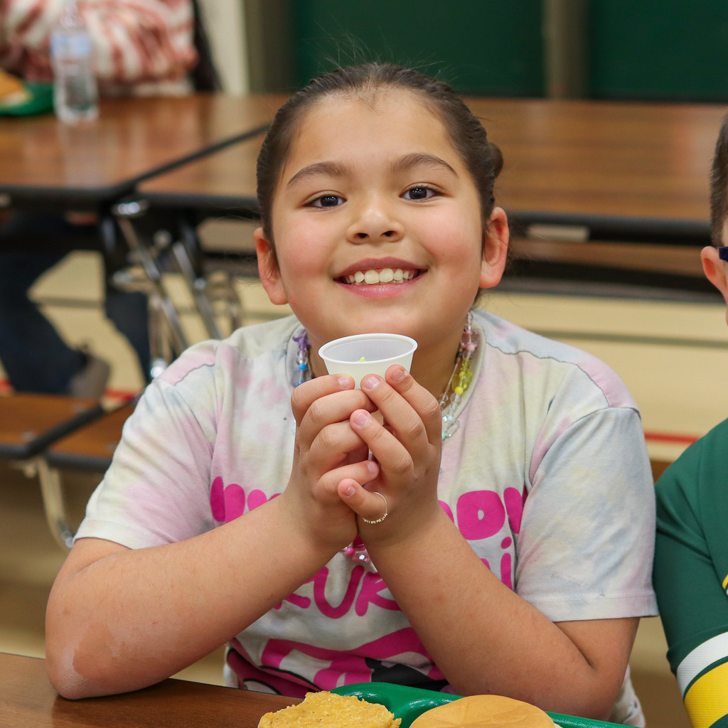 student holding up their green hummus sample 