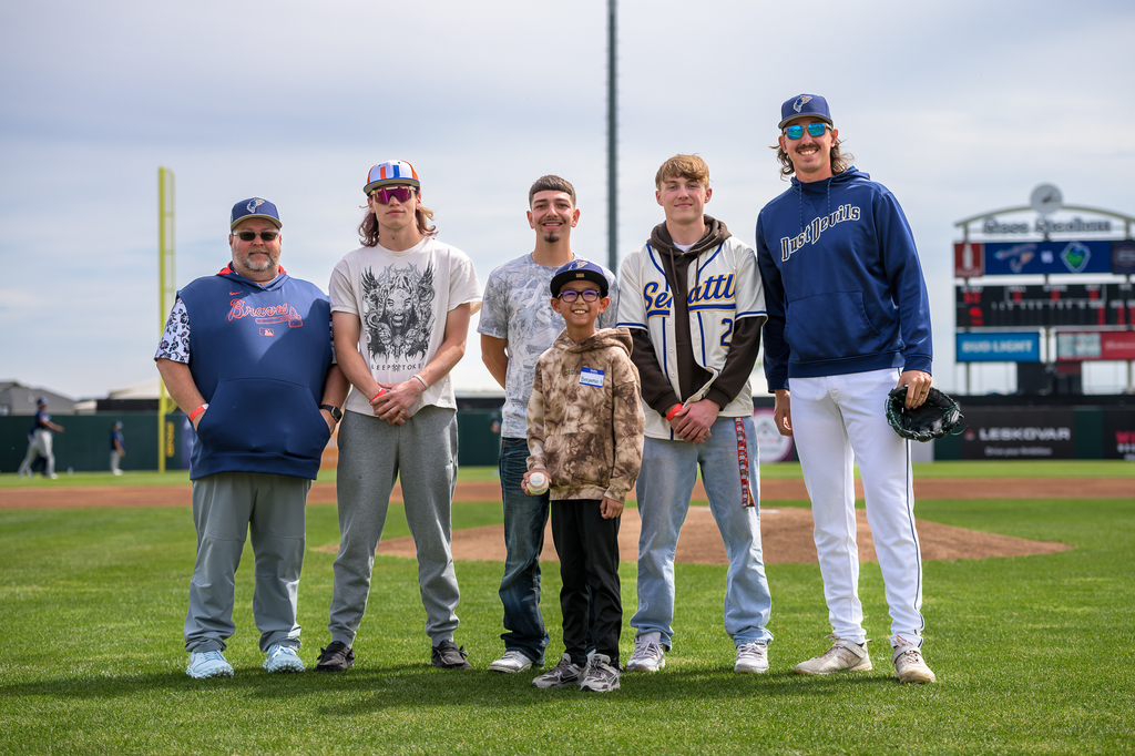 Photo of Coach Coyle with seniors who threw out ceremonial first pitches and Dust Devils player and participant from Dust Devils Youth Clinic 