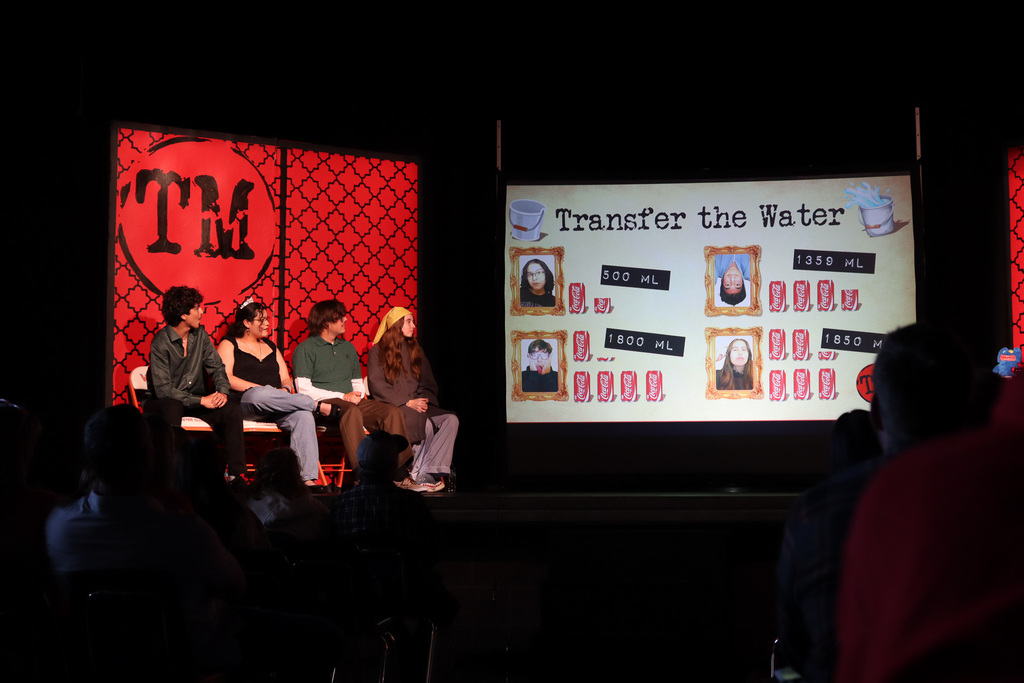 Board showing how much water contestants were able to transfer from one bucket to another using random objects