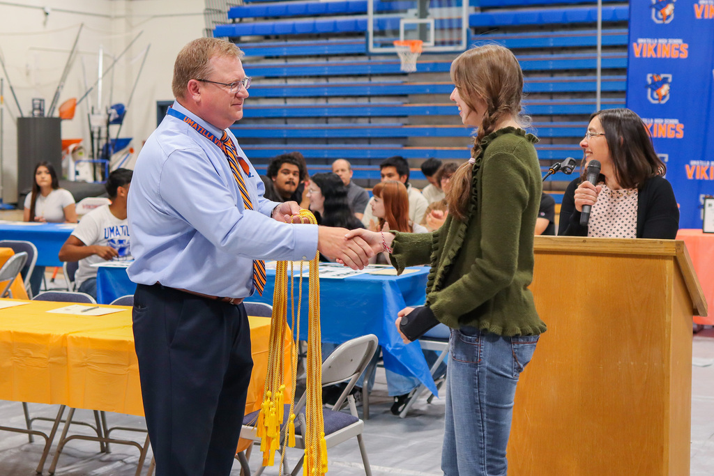 senior receiving honor cord from Principal Mr. Lorence