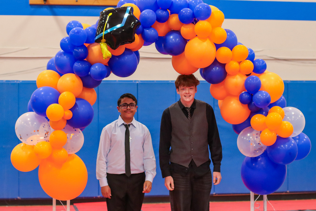 Students standing under balloon arch