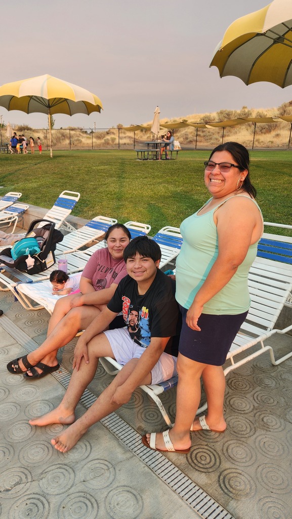 family lounging in chairs by the pool
