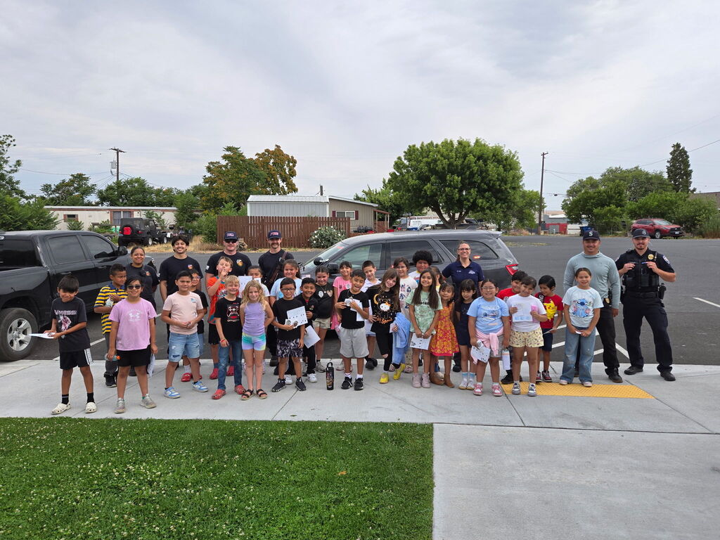Group photo of students with fire fighters at park 