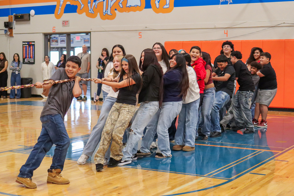 Middle school students battling against each other in a game of Tug-A-War at the welcome back assembly 