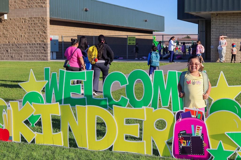 Photo of kinder with "Welcome Kinder" Card my Yard Sign