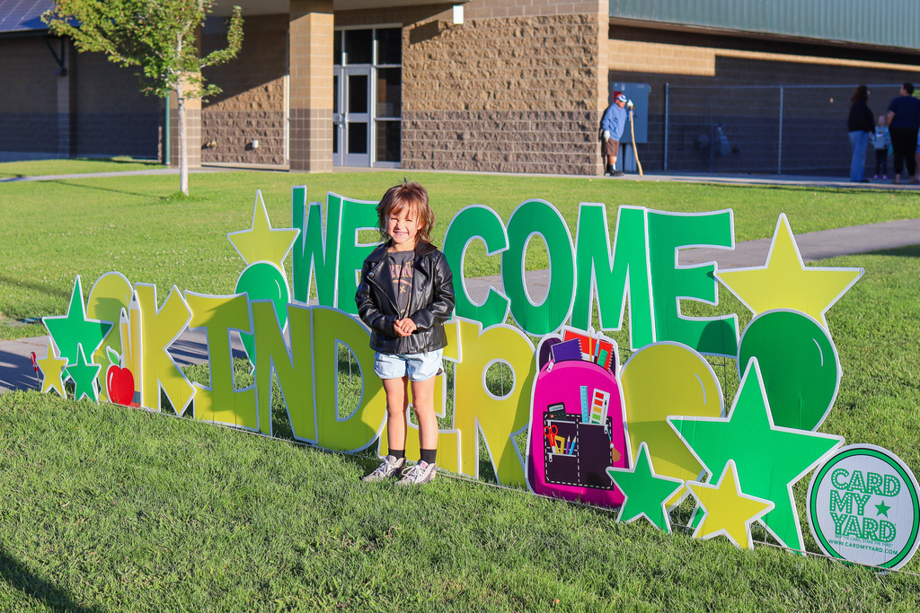 Photo of kinder with "Welcome Kinder" Card my Yard Sign