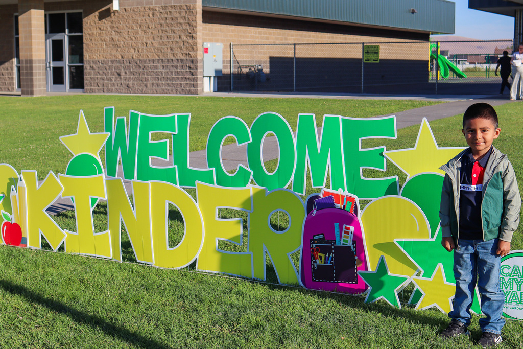 Photo of kinder with "Welcome Kinder" Card my Yard Sign