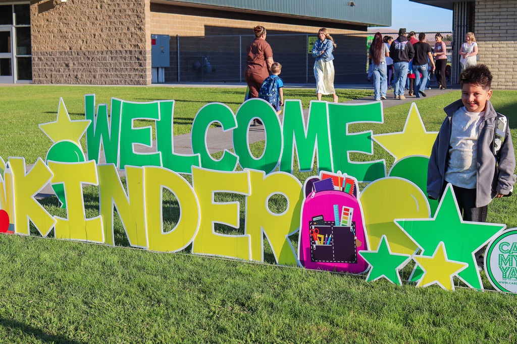 Photo of kinder with "Welcome Kinder" Card my Yard Sign