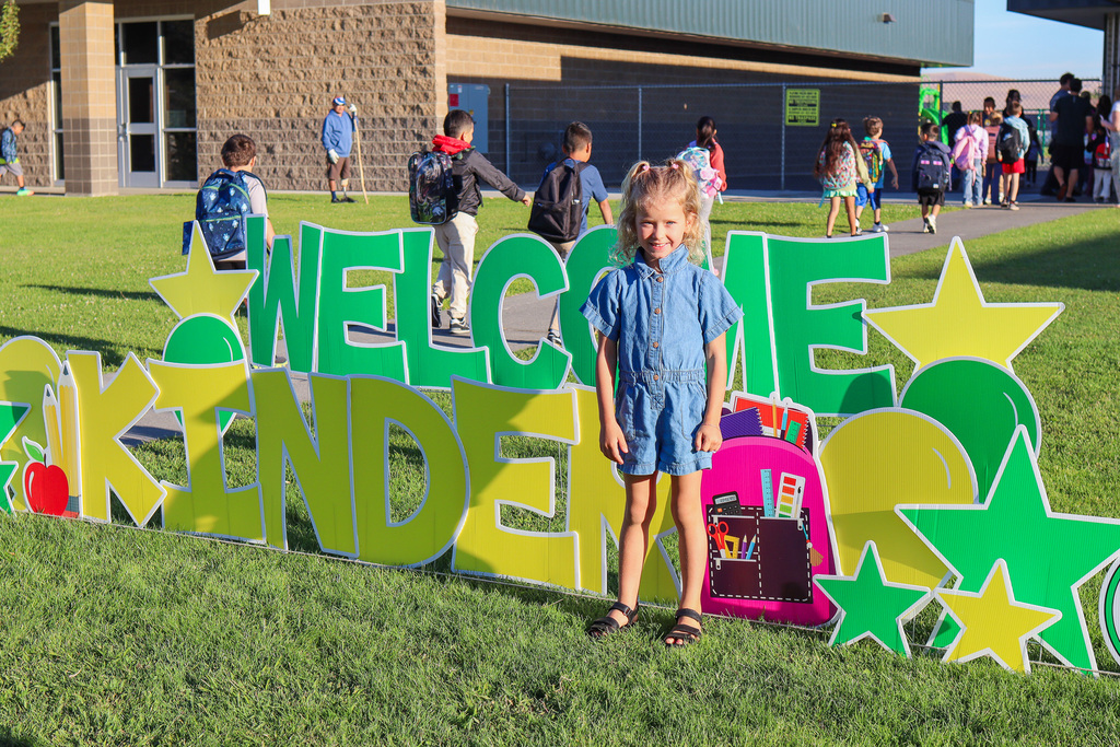 Photo of kinder with "Welcome Kinder" Card my Yard Sign