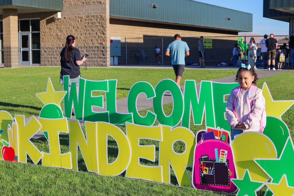Photo of kinder with "Welcome Kinder" Card my Yard Sign
