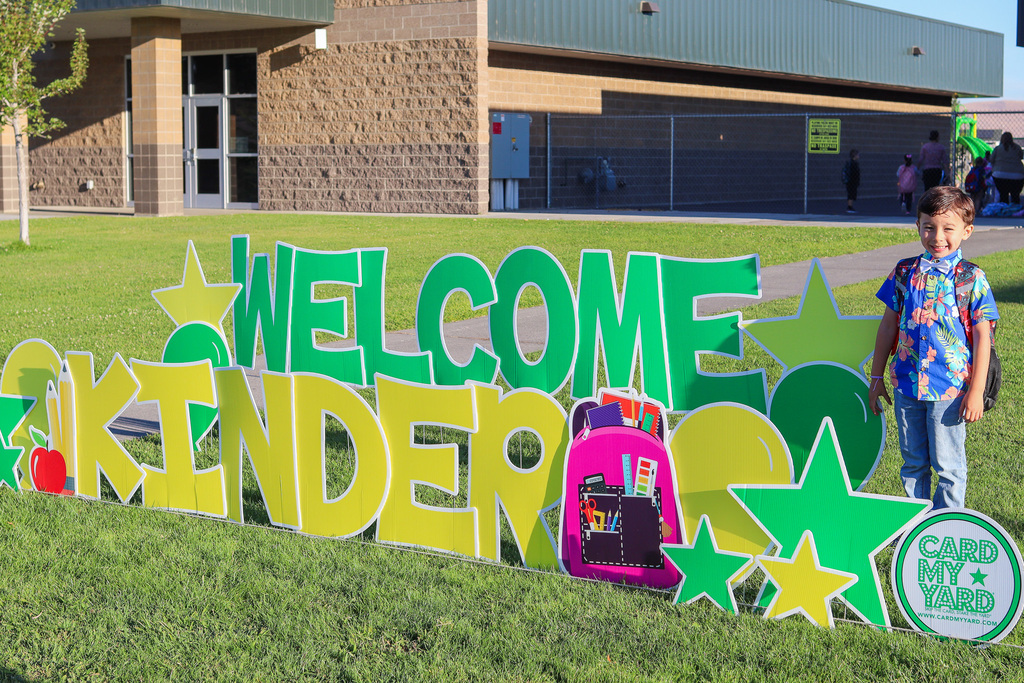 Photo of kinder with "Welcome Kinder" Card my Yard Sign