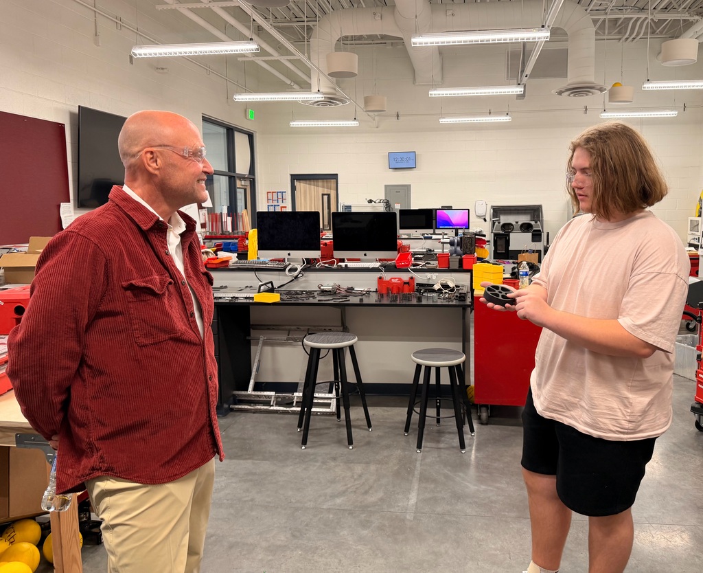 Wyatt showing Rep. Greg Smith a wheel his robotics team printed
