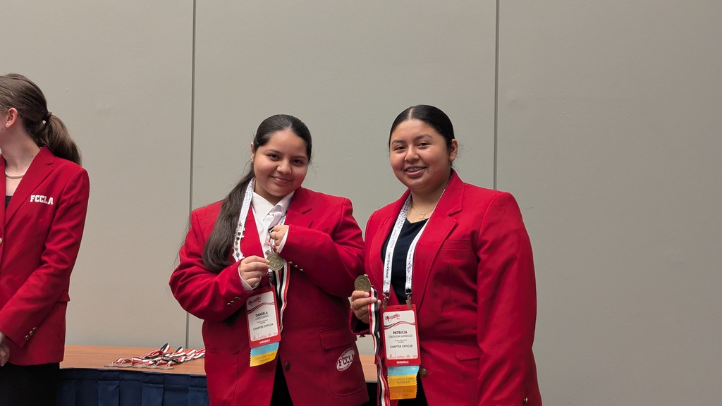 Daniela and Patricia holding gold medals they earned for their project