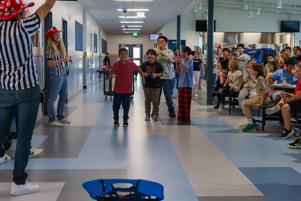 REP drawing winner successfully making the bean bag toss and students and staff celebrating