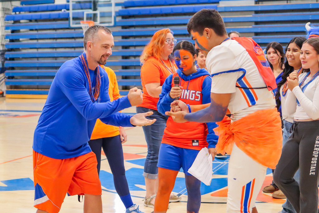 Student playing rock paper scissors game with Mr. Bow during UHS Homecoming Assembly