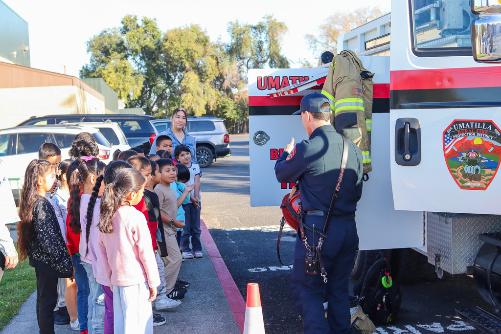 Umatilla Firefighter showing students the helmet and other gear he uses