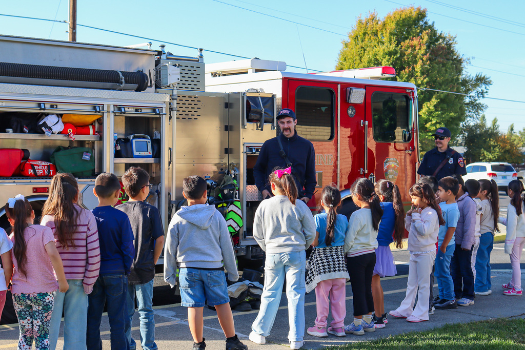 Umatilla Firefighter speaking with students in front of fire truck