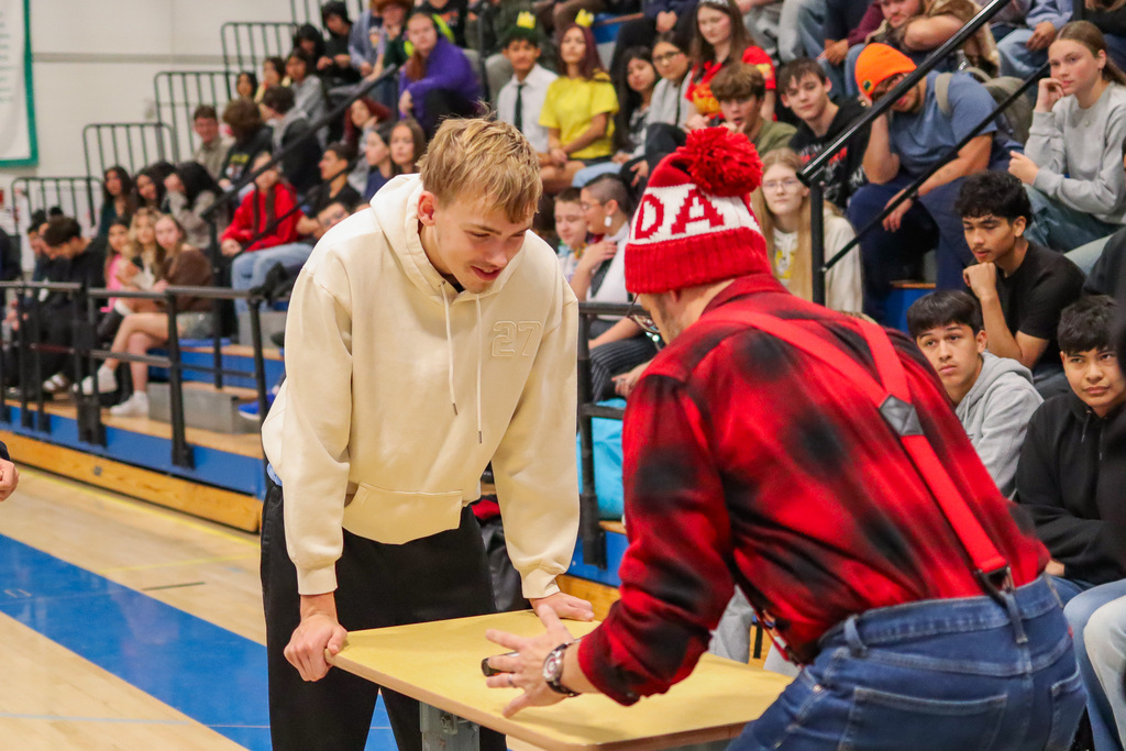 Mr. Hill and student waiting to see who can guess the next song the fast at the UHS assembly