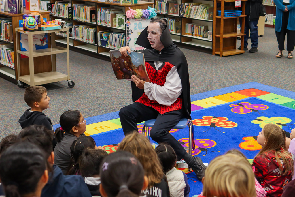 Mr. Lougee dressed as Dracula while reading a spooky story to students at MHES