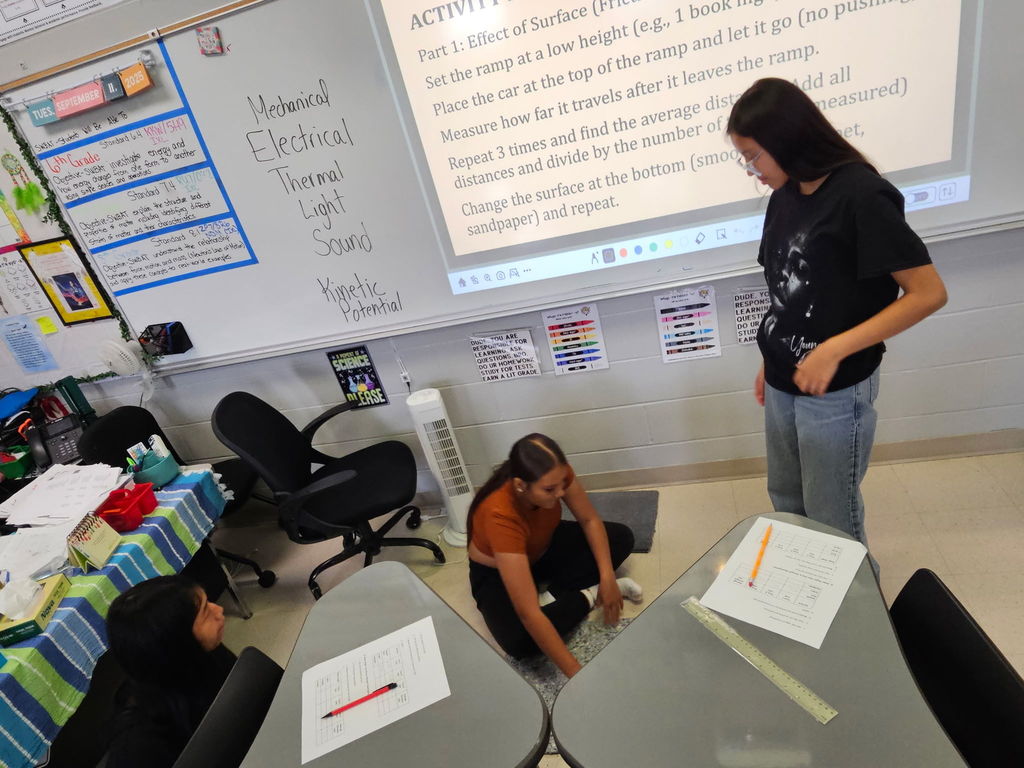 8th-grade students are all hands on when it comes to learning.  Here they are conducting a forces and motion lab while learning about friction.