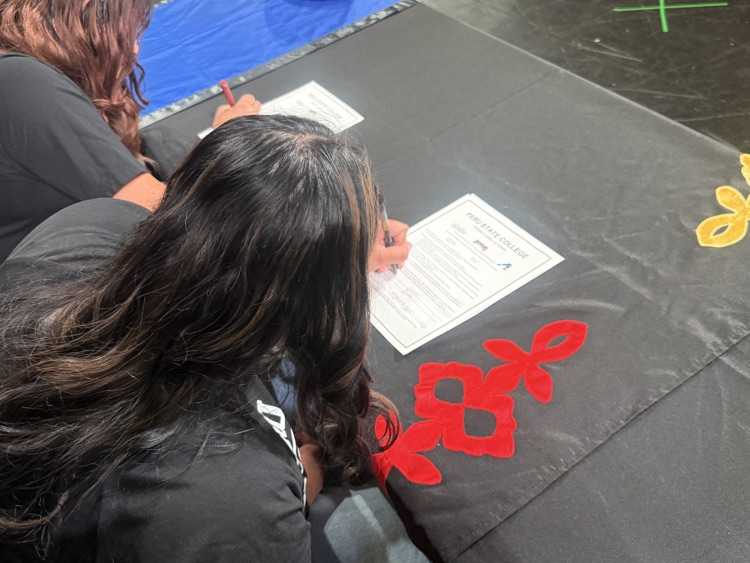 over the shoulder POV of signing college commitment contracts