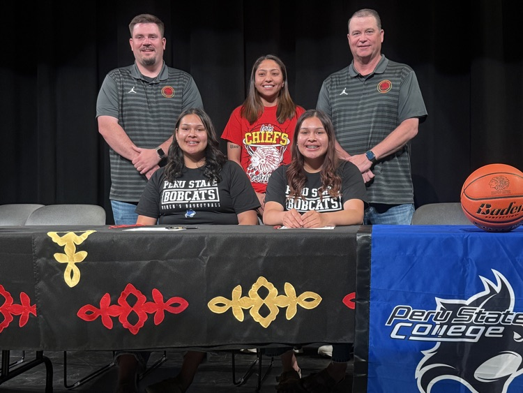 Desma and Dailene at signing table with Omaha Nation Athletics staff