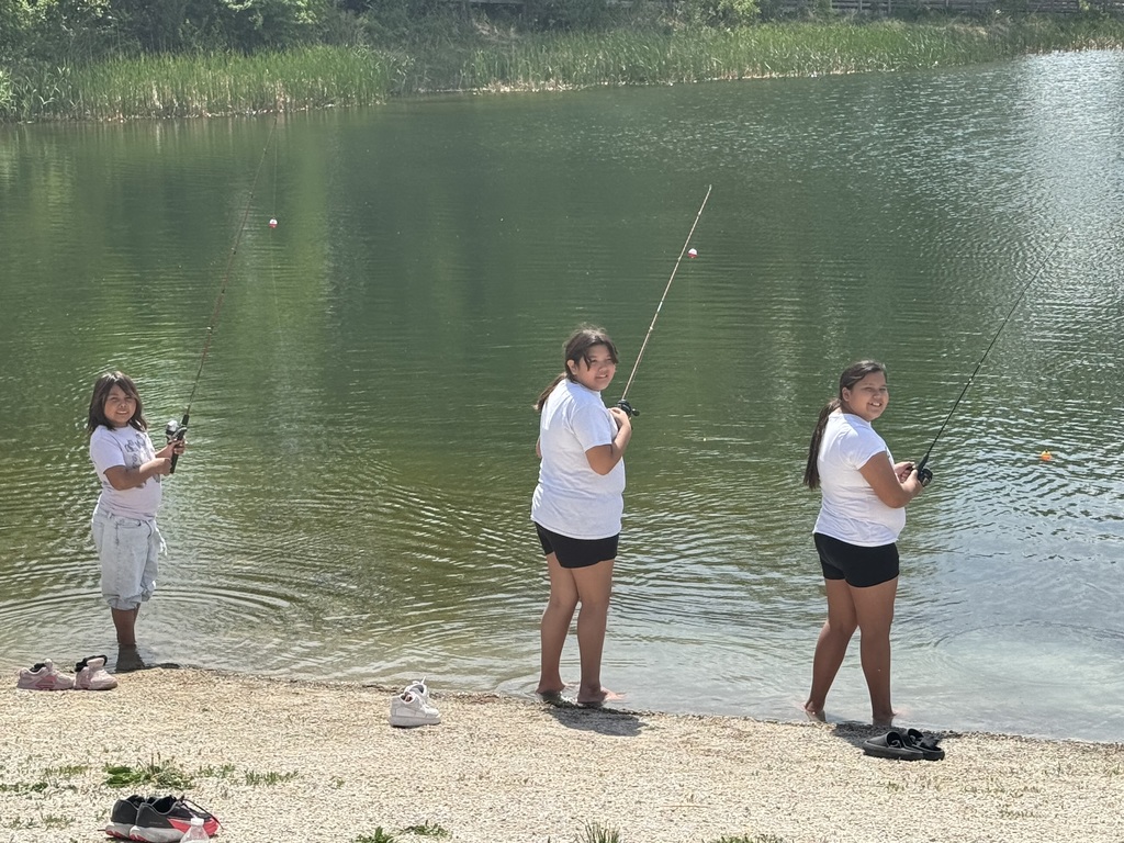 Three students fishing while wading in the water