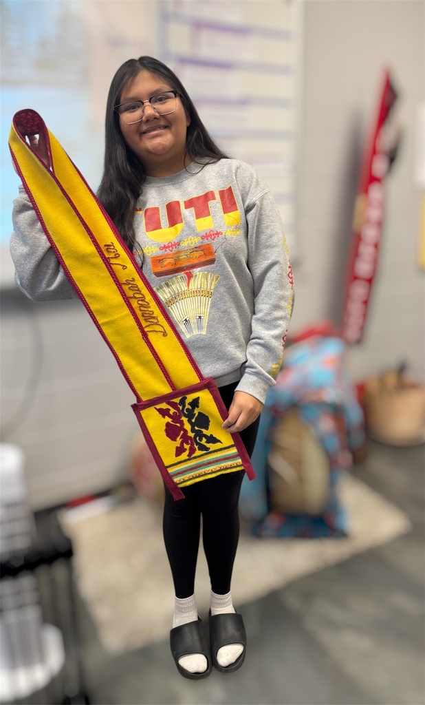 Student holds yellow and red crossbody bag