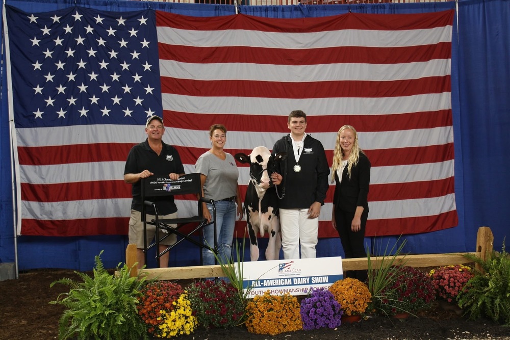 A student stands with three people on stage