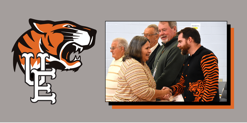 U-E Logo and JFS Staff member shaking hands with U-E Board Member