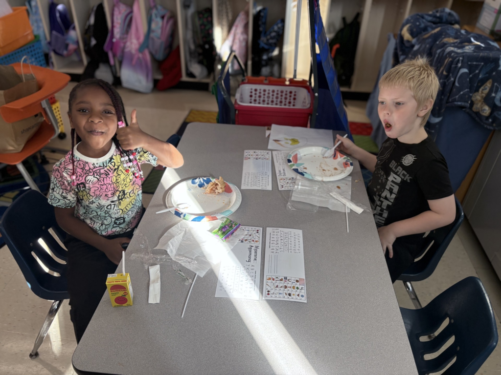 Elementary students enjoying homemade apple treats. One student is giving the camera a thumbs-up.