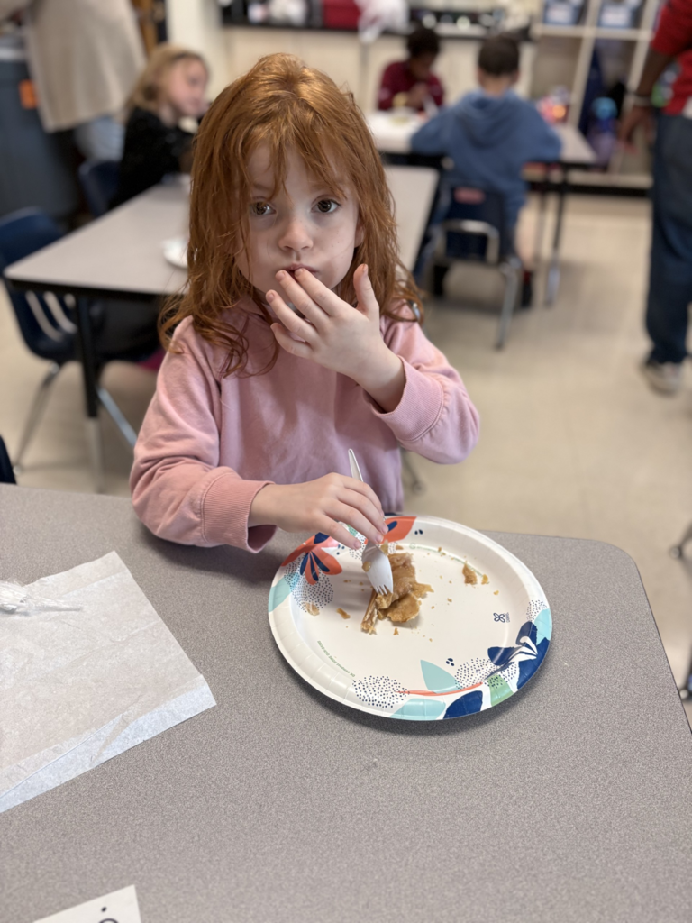 An elementary student eating an apple treat