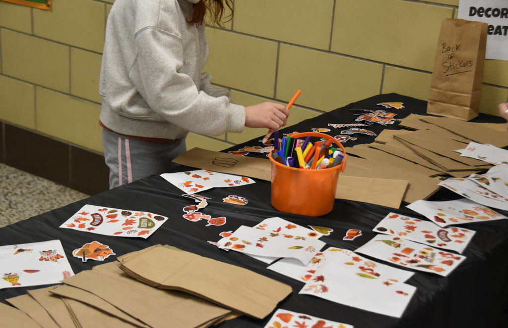 A student is choosing an orange marker from a bucket to draw with