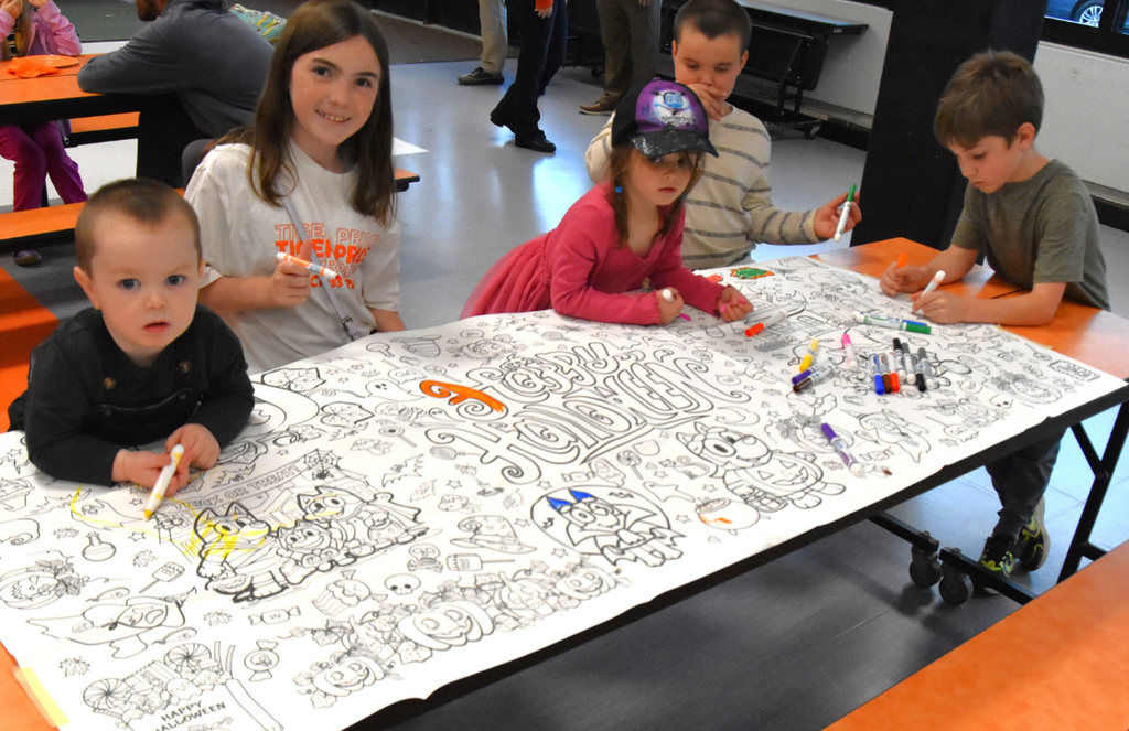 Students drawing on a large coloring sheet