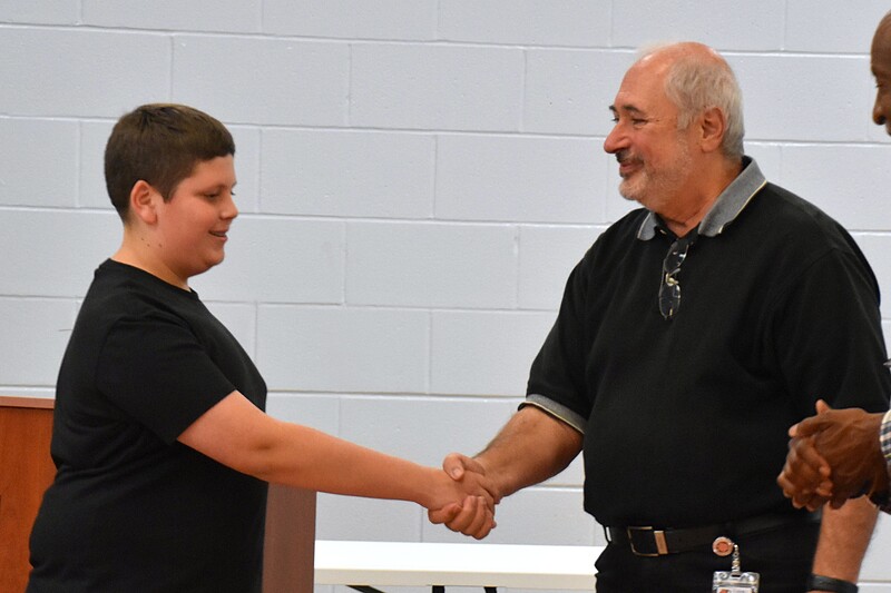 JFS student shaking hands with board member.