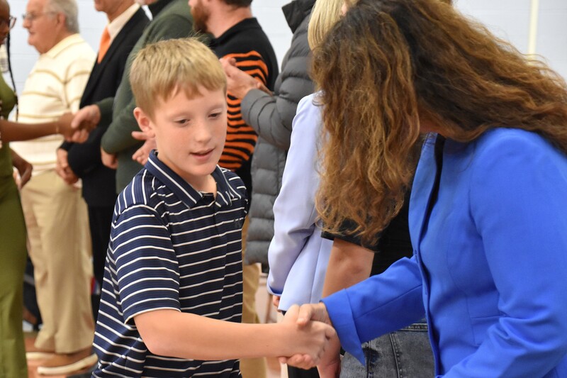 JFS student shaking hands with board member.