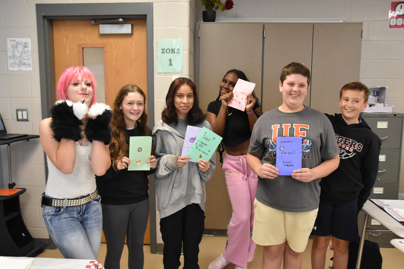 U-E middle school students holding encouragement cards