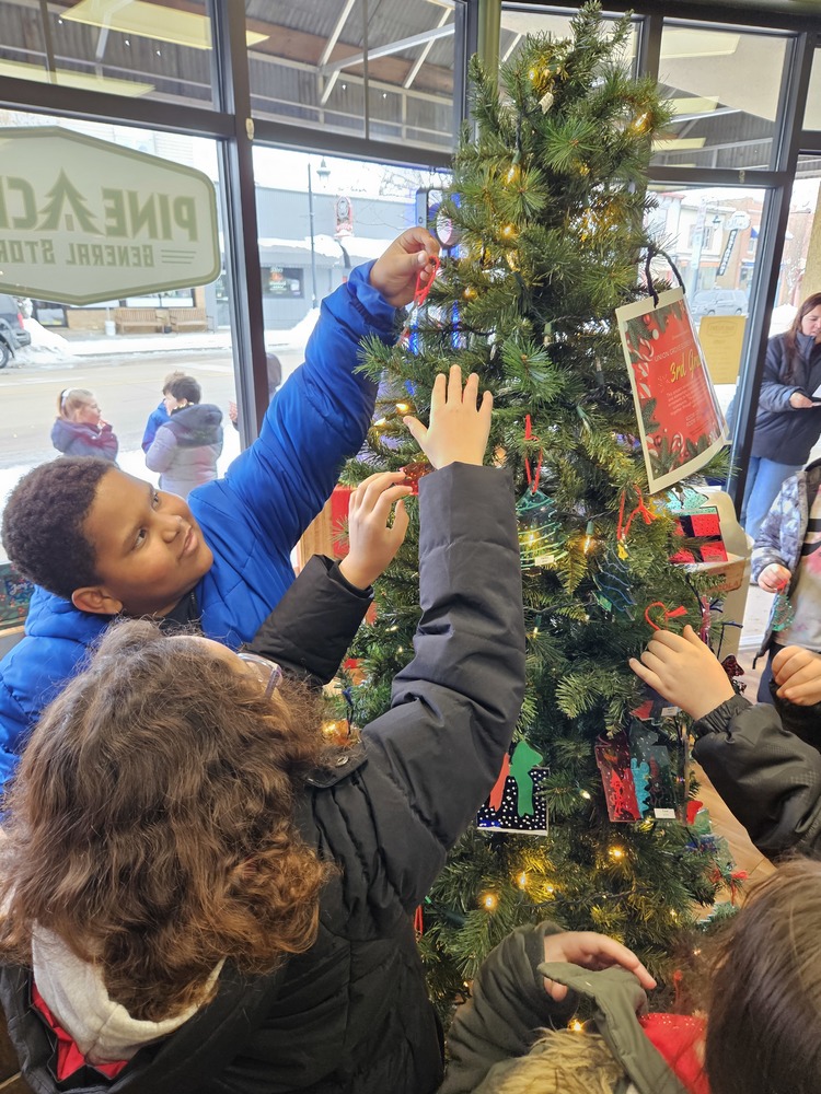 students decorate a holiday tree