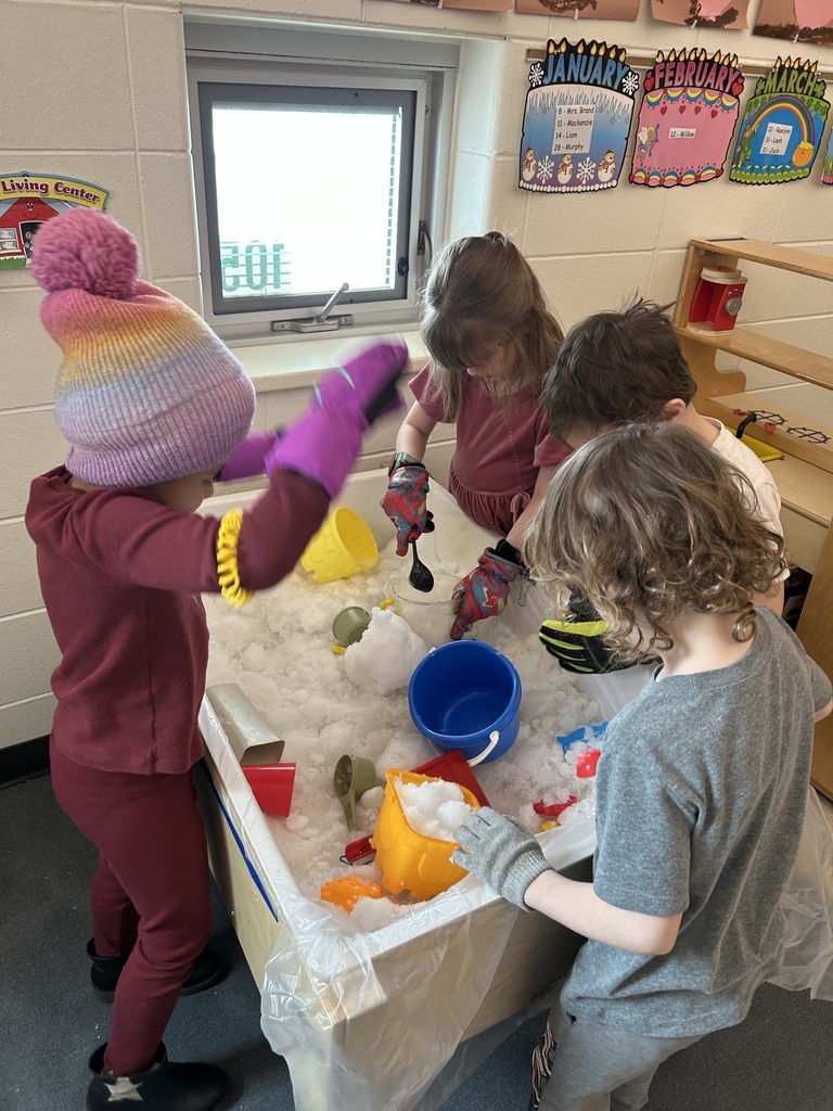 students playing with snow in a water table