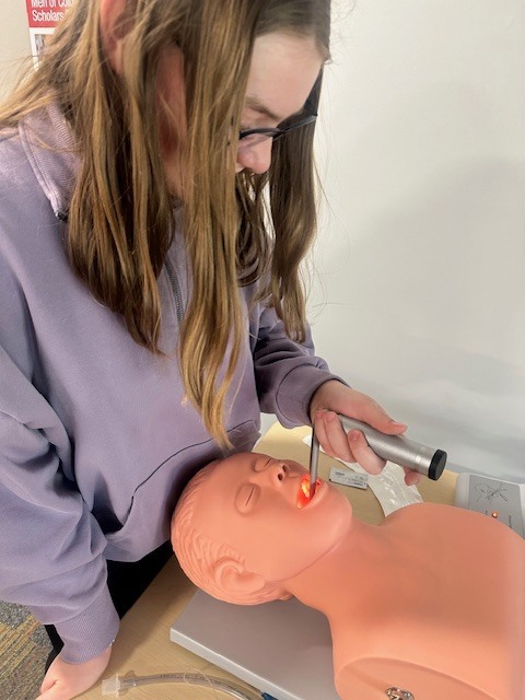 student practicing with CPR dummy