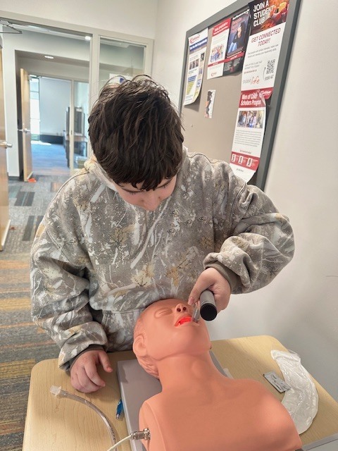 student practicing with CPR dummy