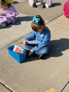 kindergarten student reading outside