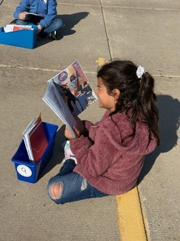 kindergarten student reading outside