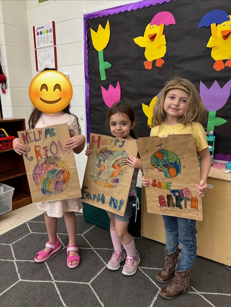 students hold their decorated paper grocery bags
