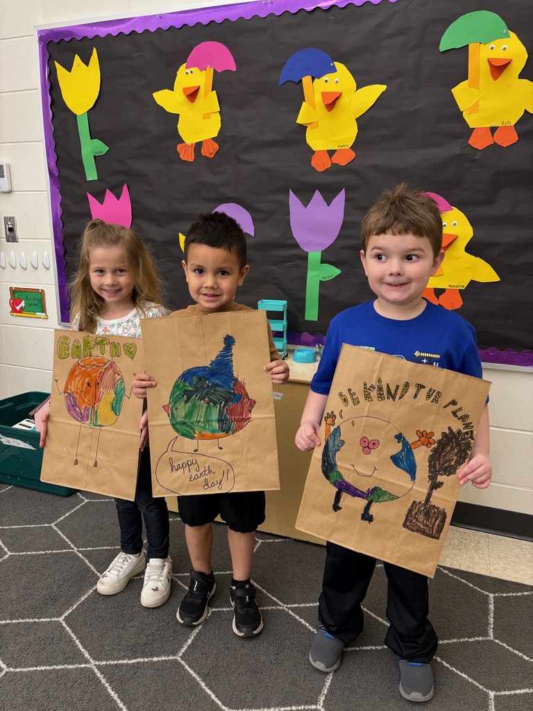 students hold their decorated paper grocery bags