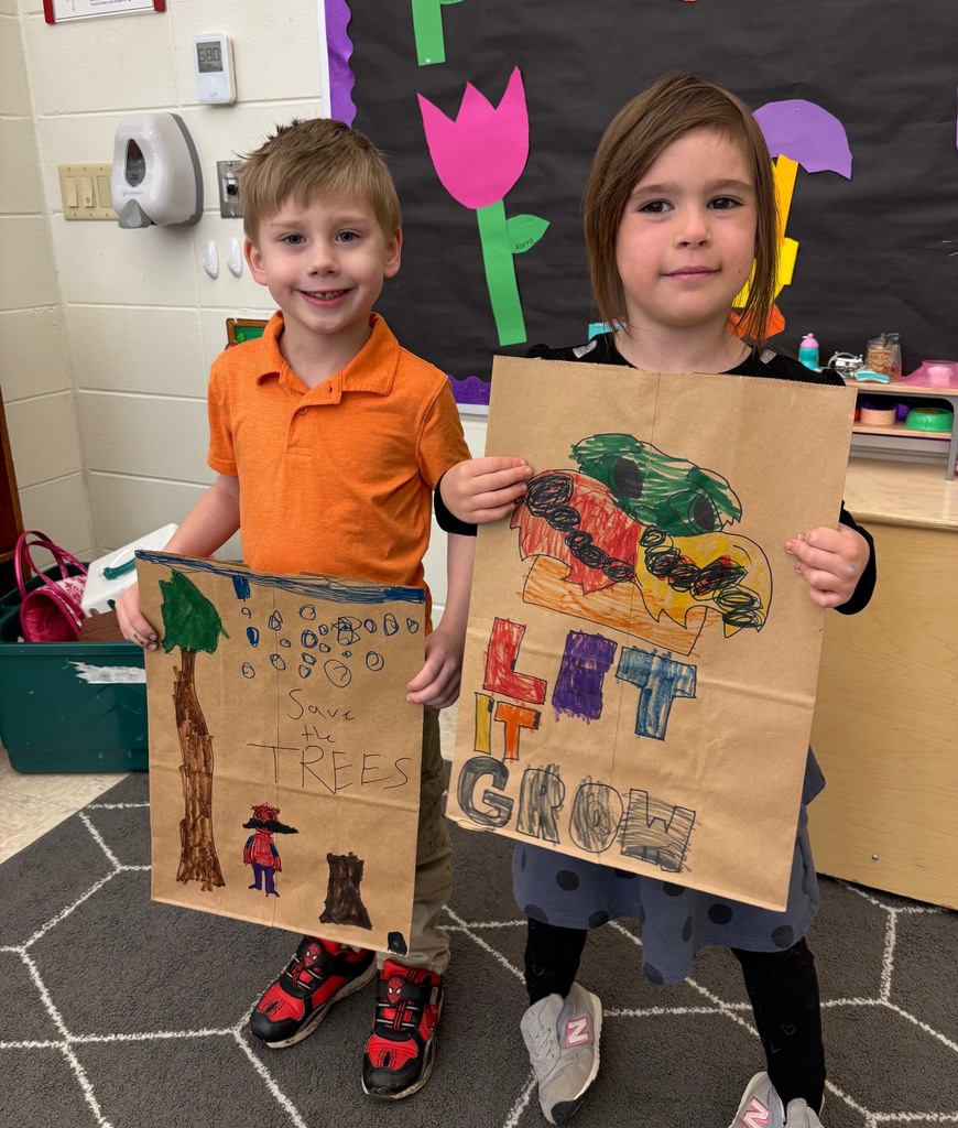 students hold their decorated paper grocery bags
