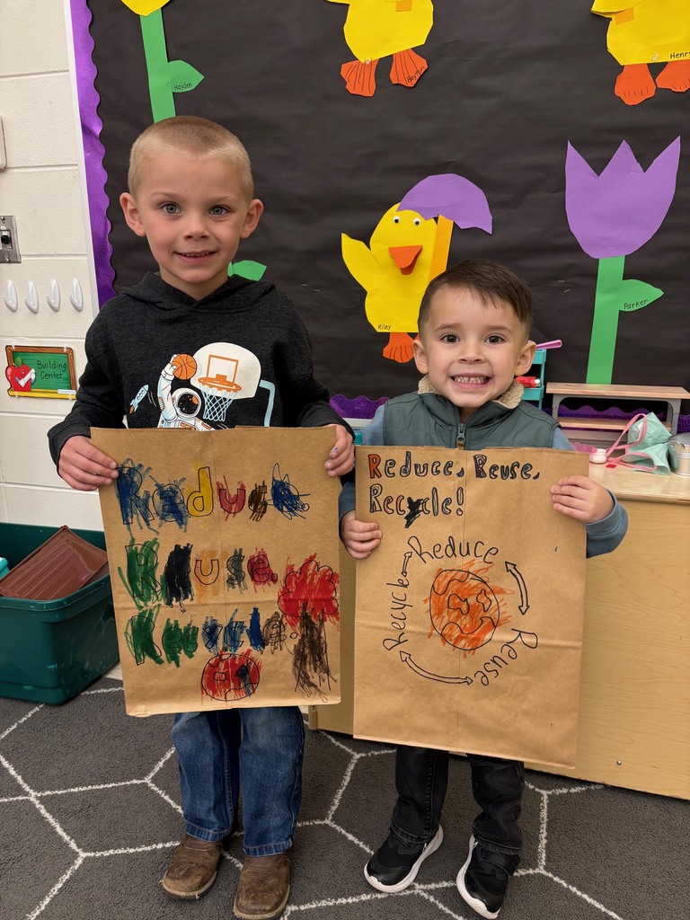students hold their decorated paper grocery bags